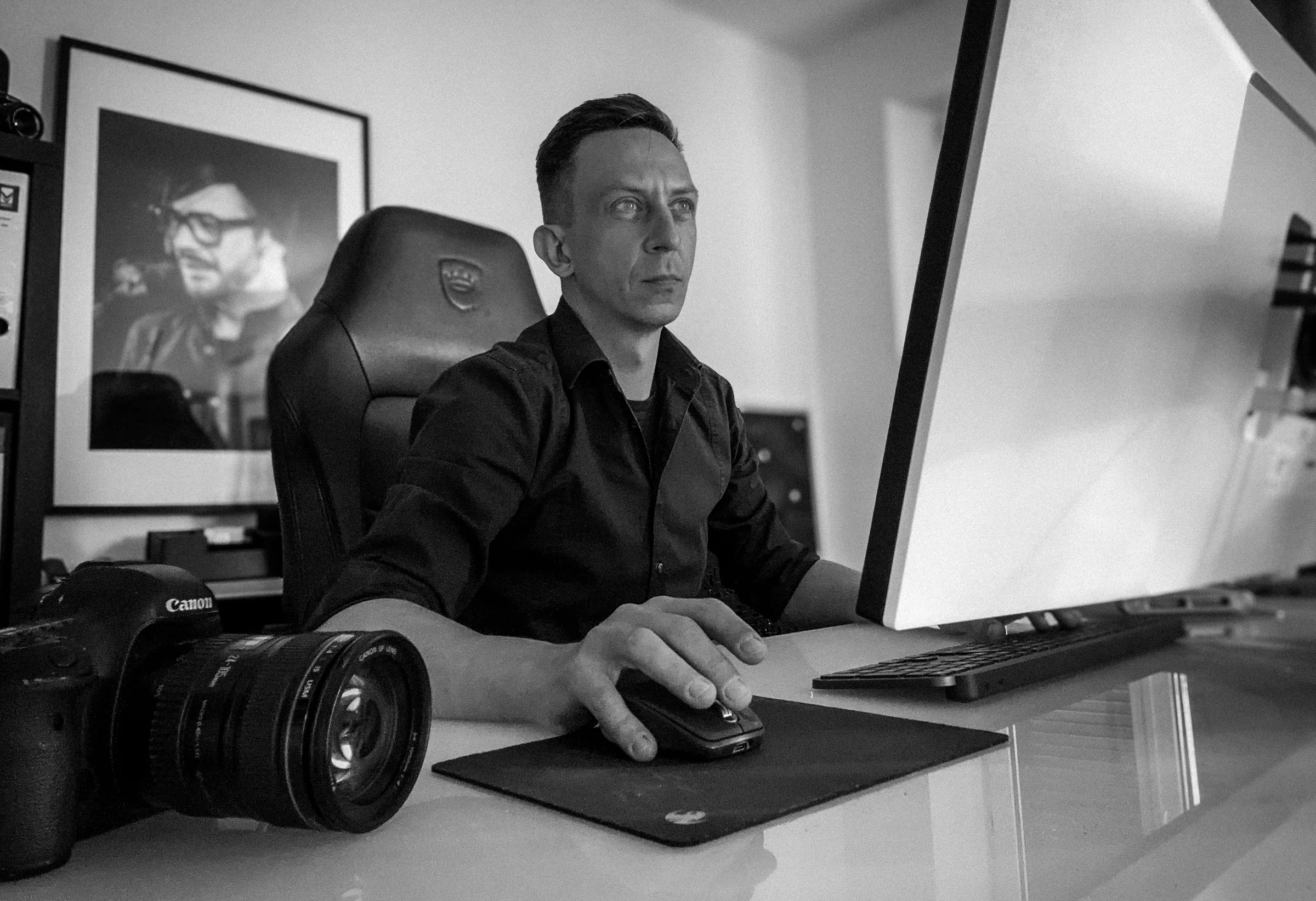 Leon Zarbock am Schreibtisch vor dem Monitor, im Vordergrund eine Canon-Kamera